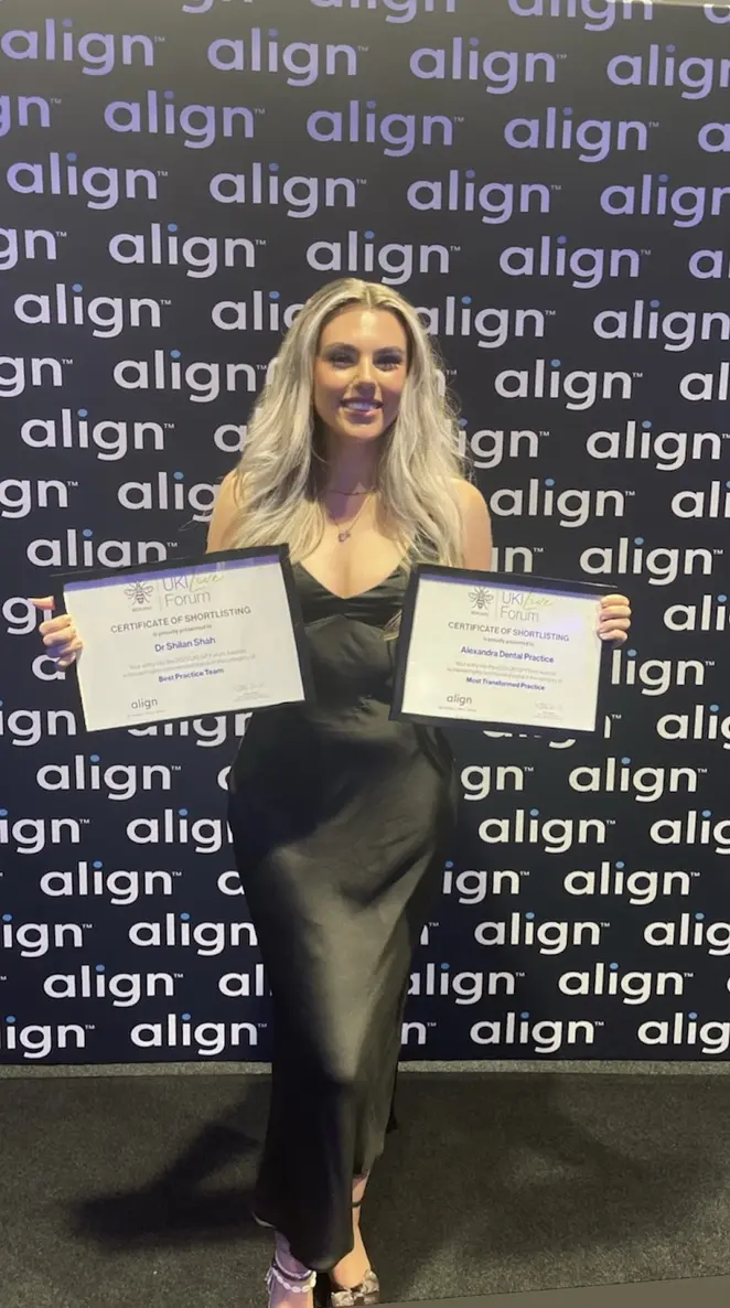 Alexandra Dental team member holding Align UK Live Forum certificates for Dr Shilan Shah and Alexandra Dental Practice